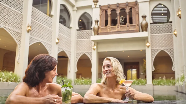 Thermen Berendonck Zwei Frauen stehen am Beckenrand und trinken einen Cocktail