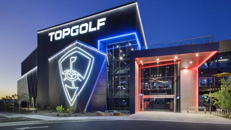 Eingangsbereich von Topgolf Oberhausen mit beleuchtetem Logo.