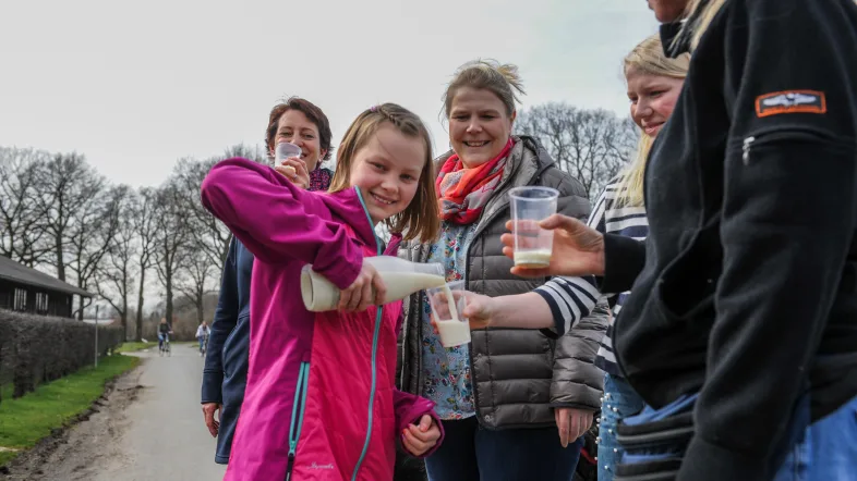 Teilnehmer schenkt frische Milch bei einer Station der Tour de Buur in Dorsten ein.