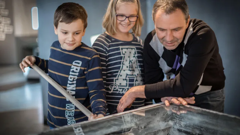 Familie schaut ein Ausstellungsstück in den Salzwelten in Bad Sassendorf an.