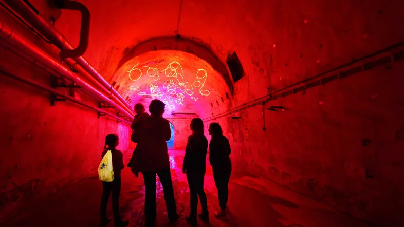 Familie im Tunnel mit orangenem Licht im Zentrum für internationale Lichtkunst in Unna.